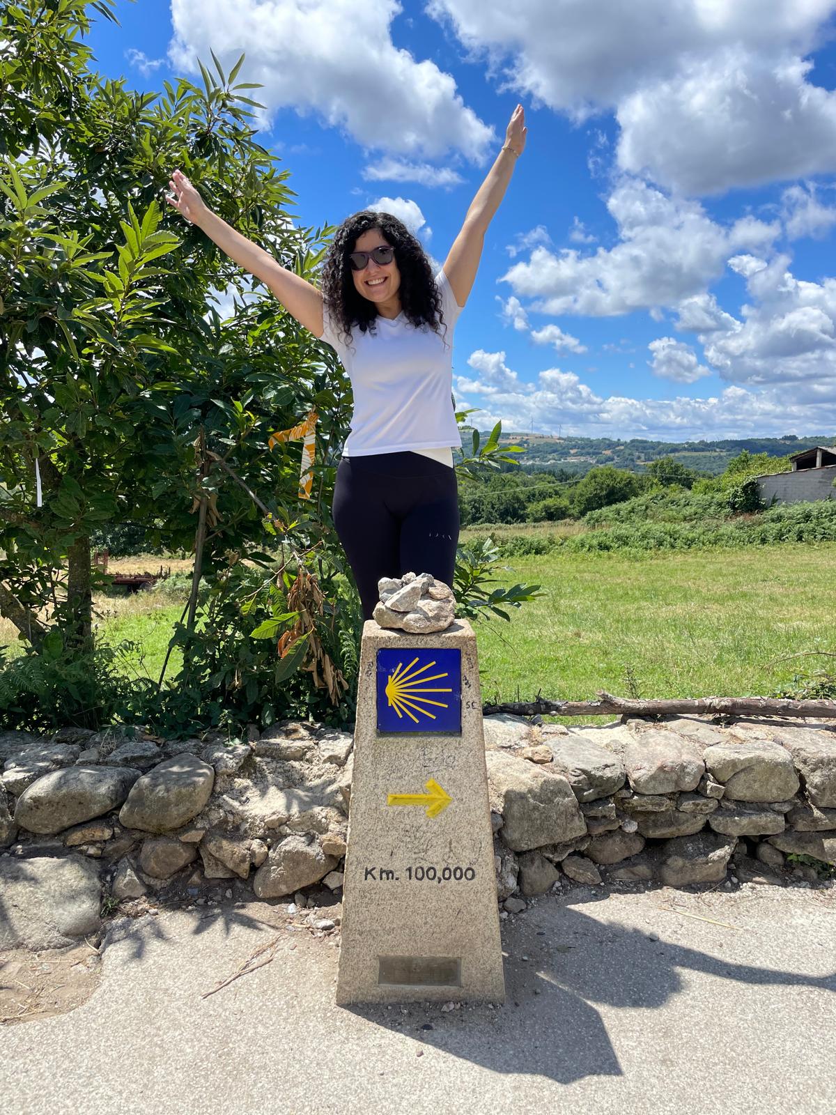 Raquel, fundadora de Stella Viajes, en el monolito del Km. 100 del Camino Francés